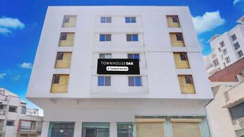 A multi-story building with a sign that reads 'TOWNHOUSE OAK Company Serviced'.