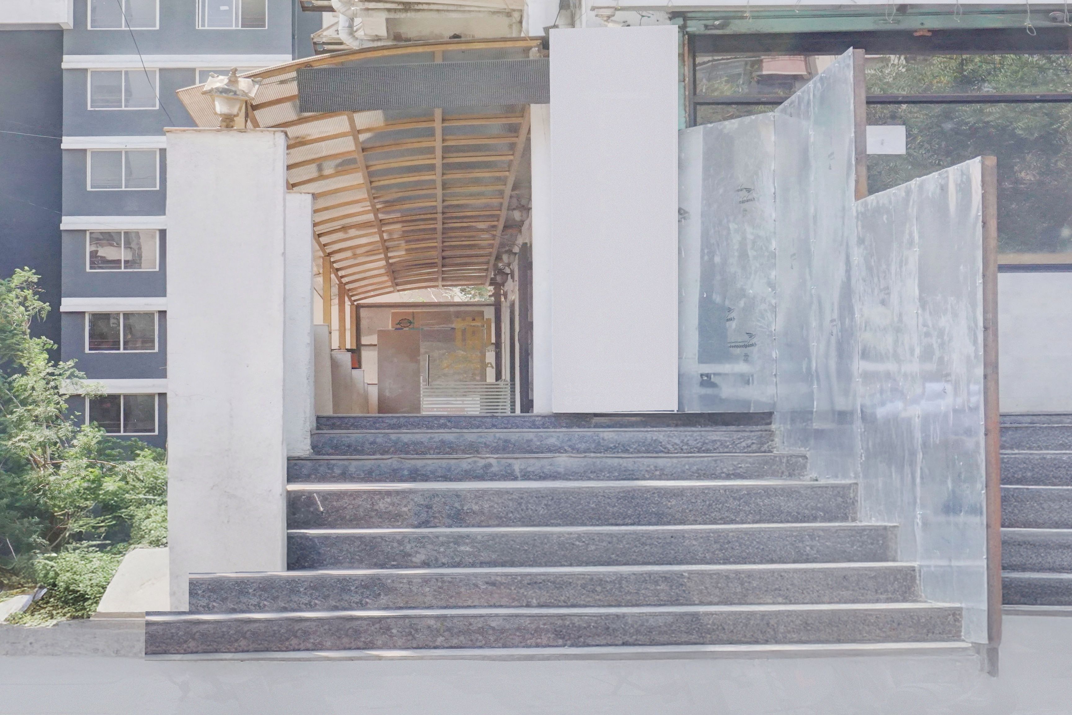Un conjunto de escaleras exteriores que conducen a un acceso cubierto con una puerta de metal.