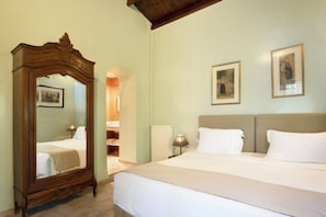 A hotel room with a large mirror, a bed with white linens, a headboard, and two framed pictures on the wall. - PELECAS COUNTRY CLUB (Corfu)