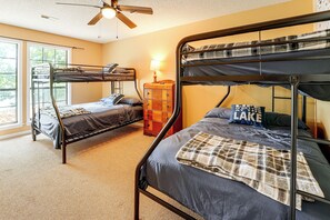 Ein Zimmer mit Etagenbetten, einem Holzschrank und einem Deckenventilator.