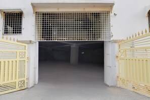 A gated entrance to a building with a metal grid over the door, a concrete floor, and a white wall. - Townhouse Nagole RTO Office (Hyderabad)