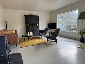 Un salon doté d’une cheminée, d’un coin salon et d’une grande fenêtre offrant une vue dégagée.