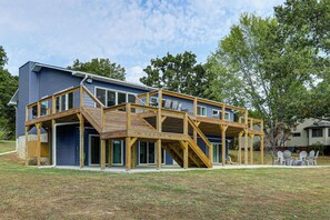 Ein zweistöckiges Haus mit einer Holzterrasse und einer Veranda.