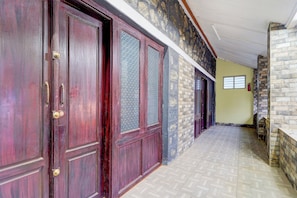 A hallway with wooden doors and stone walls.