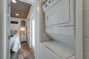 A compact hotel room with a bed, bedside table, lamp, and a view of a wooden ceiling. - 14 Mi to DuPont State Forest! Home w/ Pool Access (Flat Rock)