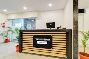 A reception desk with a sign indicating 'Company Serviced' at a property named 'Townhouse Oak'. - Townhouse OAK Owaisi Hospital (Hyderabad)