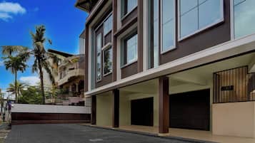 A modern building with a flat roof, large windows, and a paved ground.