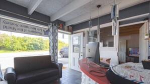 Ein Zimmer mit einer Ledersofa, einem Schreibtisch mit Computer und einem Bett mit gemustertem Überwurf.