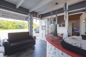 A room with a leather sofa, a desk with a computer, and a bed with a patterned bedspread. - Full Bed|Smoking|Breezewood (Breezewood)