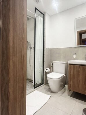 Ein Badezimmer mit Dusche, Toilette und Waschbecken.