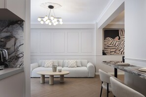 A modern interior with a marble countertop, a round table, a sofa with patterned cushions, and a unique wall art piece. - Nouar Residence I + Breakfast - ATH Center by etouri (Athens)