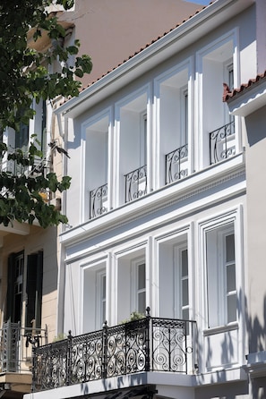 A building with white exterior walls, multiple windows with white frames, and a balcony with ornate black metal railings. - Nouar Residence I + Breakfast - ATH Center by etouri (Athens)
