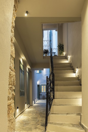 Eine Treppe mit Geländer, die zu einer Zwischenebene mit Fenster und Pflanzgefäßen führt.