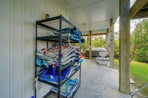 A covered outdoor area with a metal shelving unit filled with various items. - Sunset Views + Hot Tub Soaks: Topsail Beach Gem (Surf City)