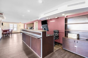 A reception area with a counter, a seating area with chairs, and a desk with a computer. - King Bed Non Smoking (Tulsa)