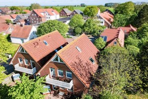 Ein Wohngebiet mit Häusern, die rote Dächer und weiße Balkone haben.