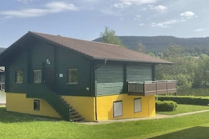 A two-story building with a balcony, a staircase, and a small window. - by the lake with views of the lake and the Bavarian Forest, ground floor (Arrach\/ Kummersdorf)