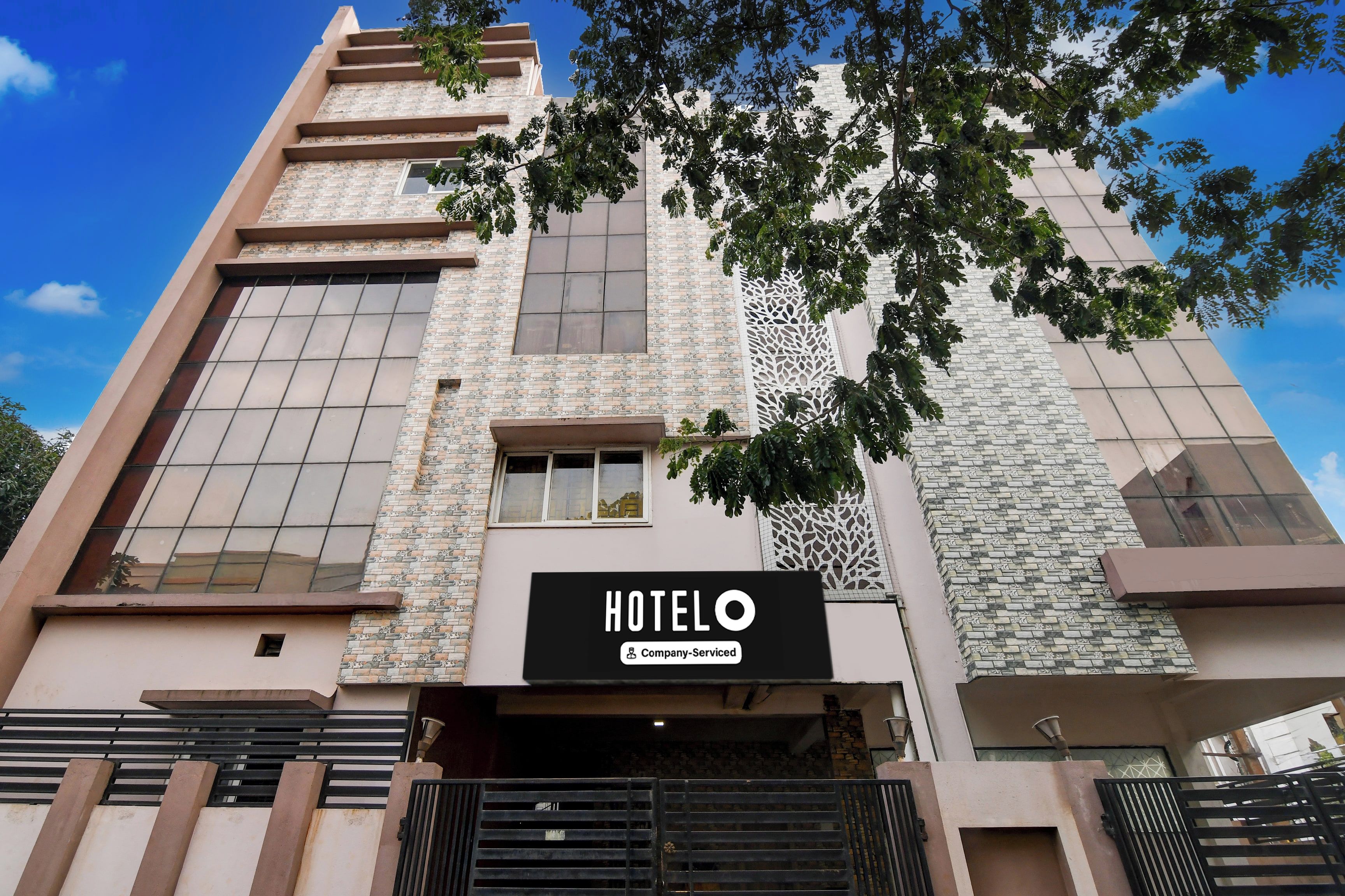 A hotel building with a sign indicating it is company-serviced.