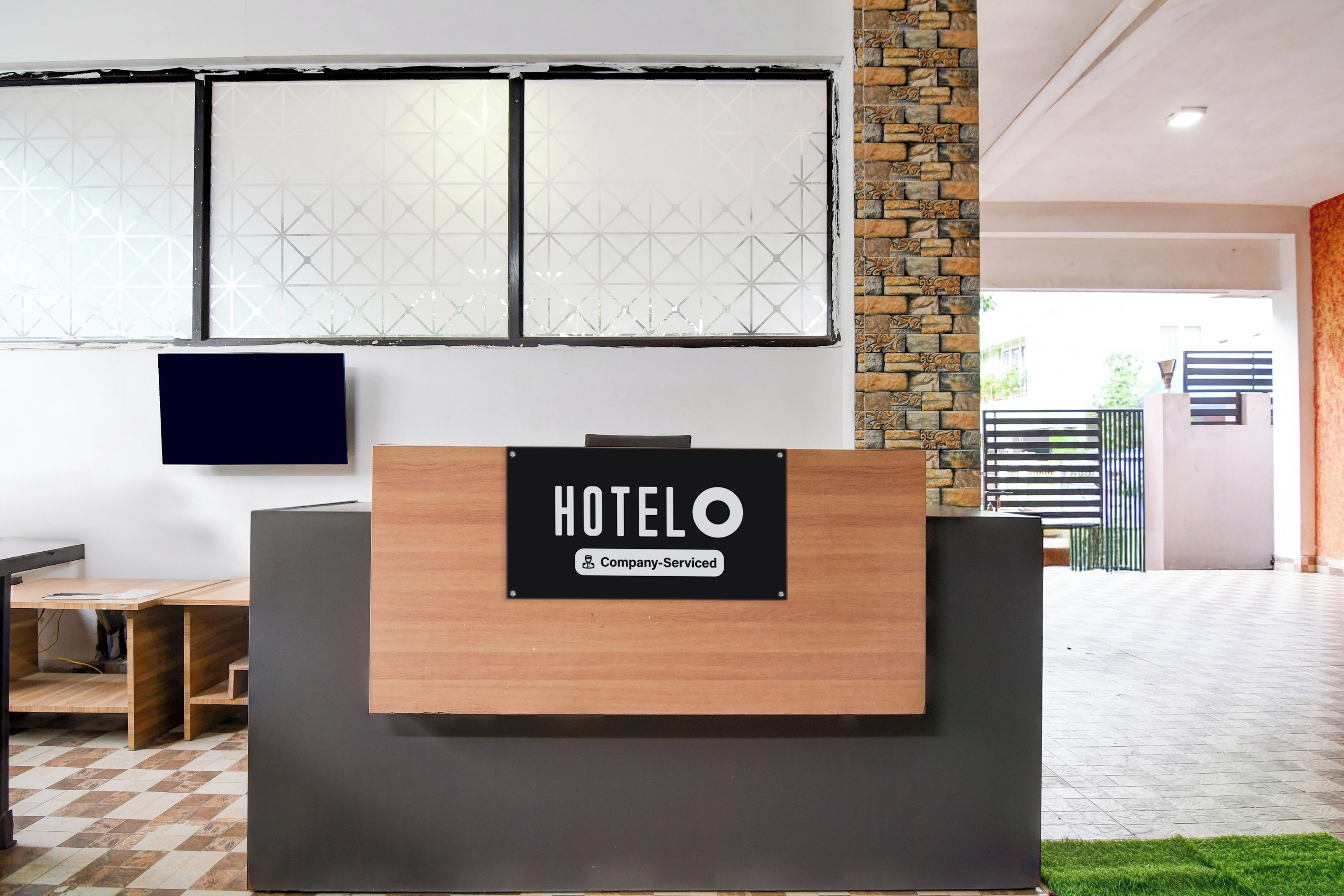 Ein Hotelrezeptionstisch mit einem Schild, das anzeigt, dass er vom Unternehmen gestellt wird.