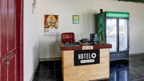 A hotel reception desk with a sign indicating it is company-serviced. - Hotel O Chirala Beach View (Chirala)