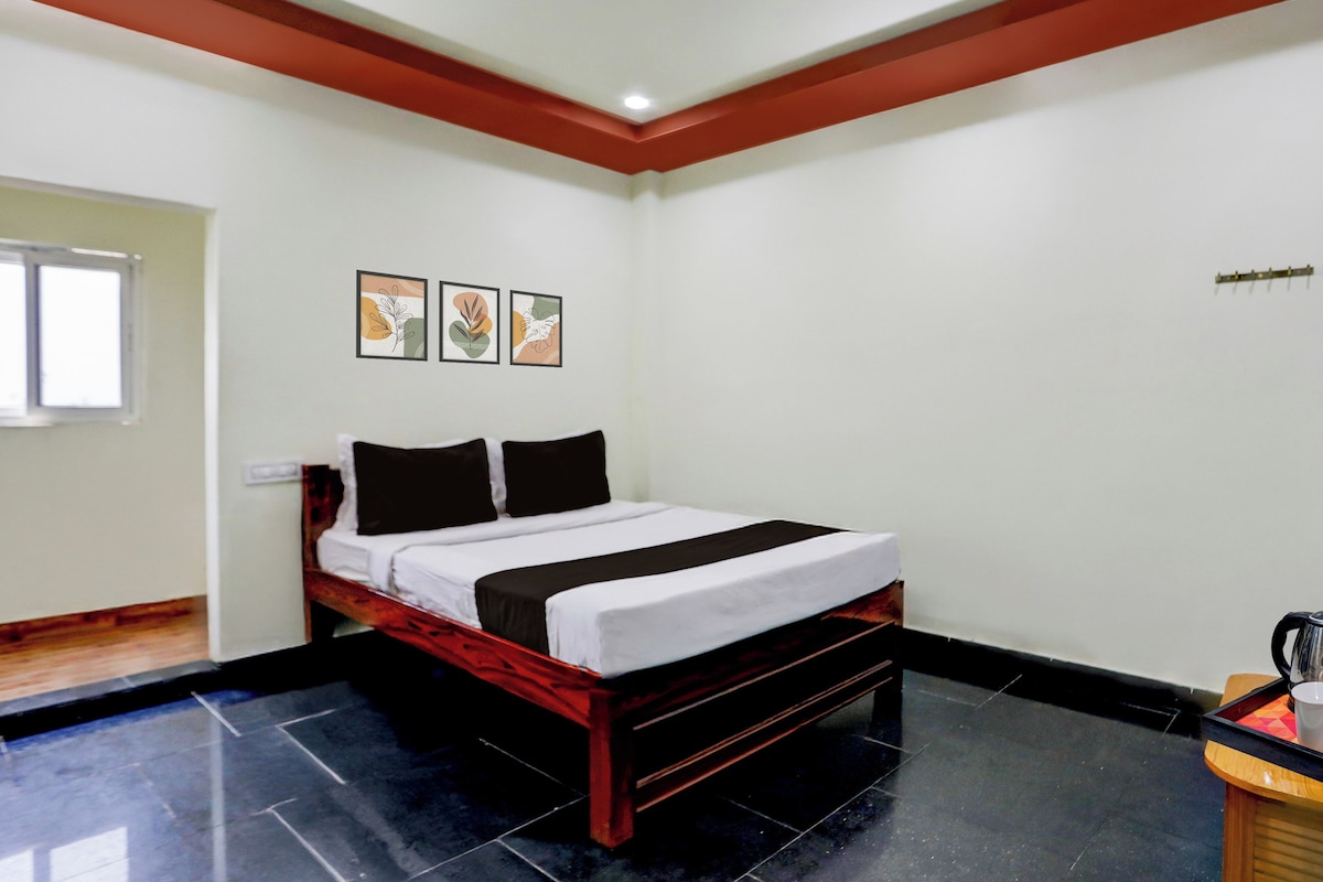 A hotel room with a bed, a small table, and artwork on the wall.