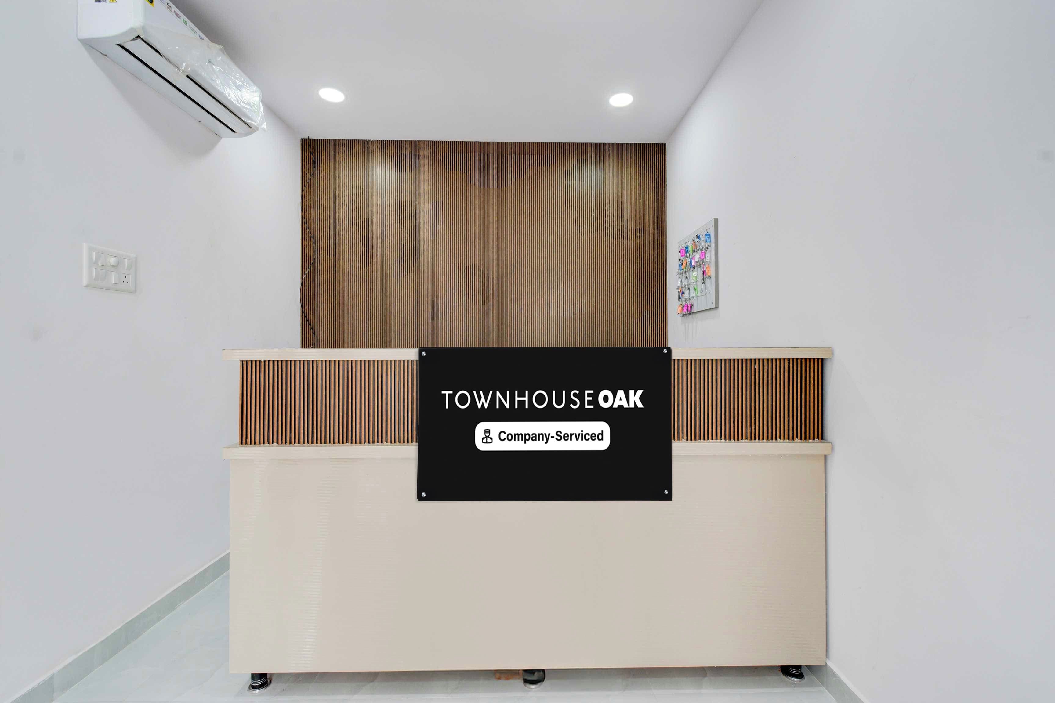 A reception desk with a sign that reads 'TOWNHOUSE OAK Company-Serviced'.
