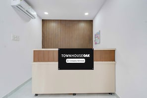 A reception desk with a sign that reads 'TOWNHOUSE OAK Company-Serviced'. - Townhouse Oak Townhouse Oak BN Reddy (Hyderabad)