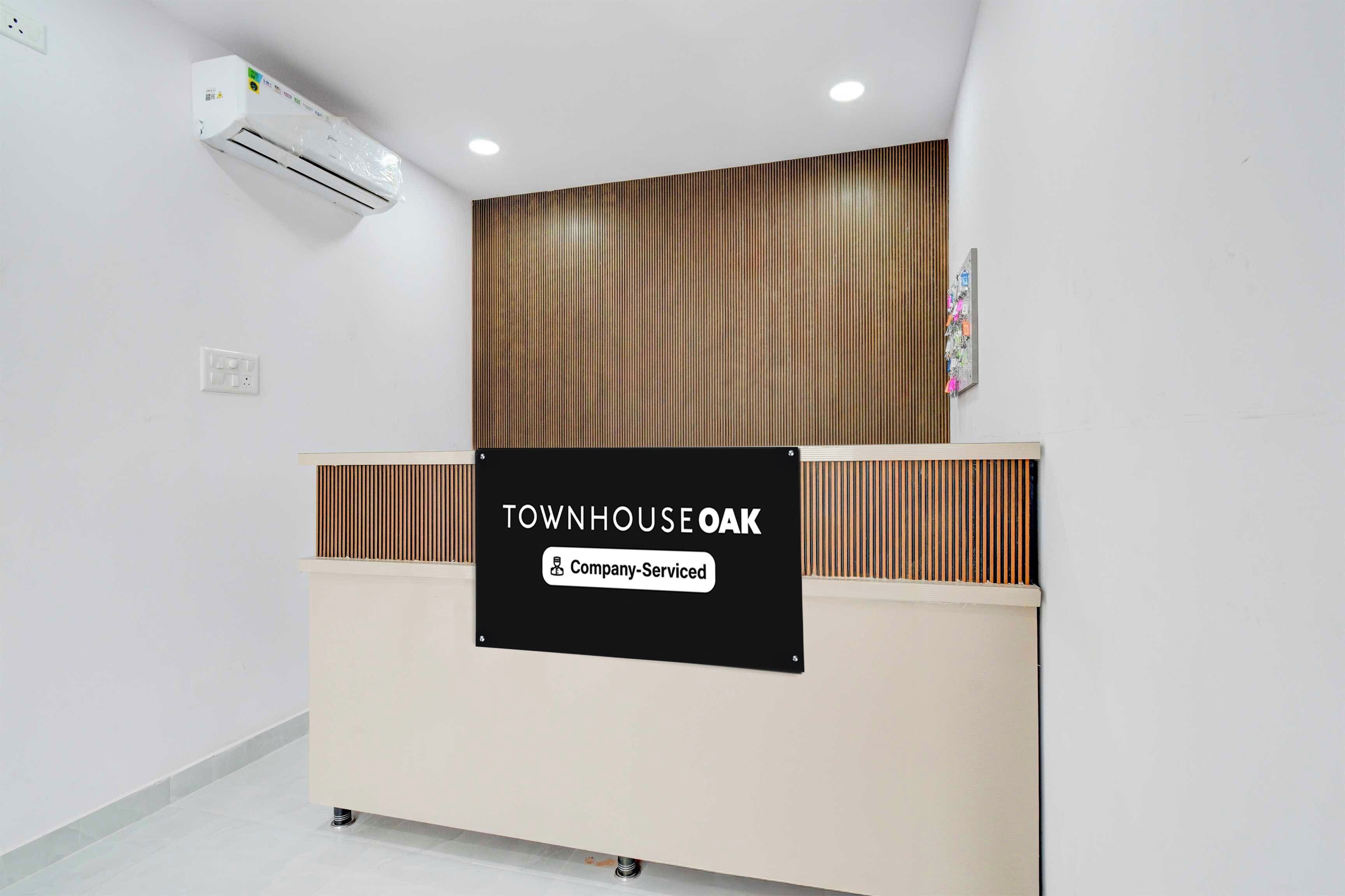 Una mesa de recepción con un cartel que dice 'TOWN HOUSE OAK Company-Serviced'.