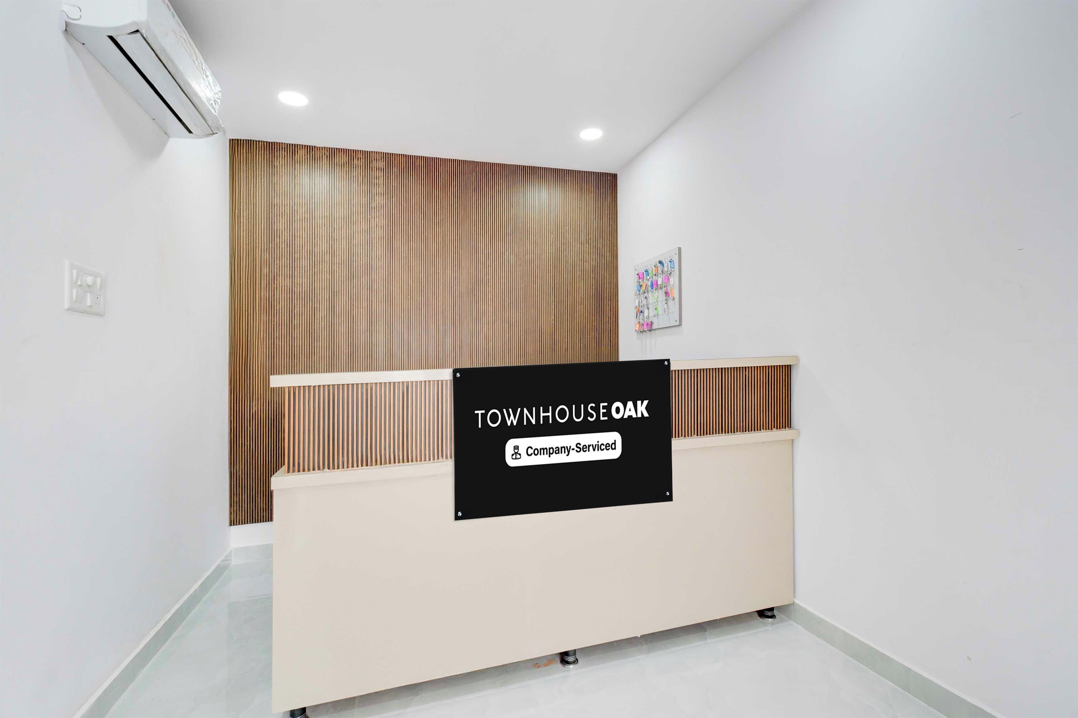 Una recepción con un letrero que indica 'TOWNHOUSE OAK Company Serviced'.