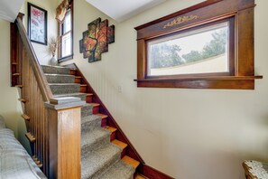 Eine Treppe mit hölzernen Geländern und Teppichstufen, die zu einer Zwischenebene führt.