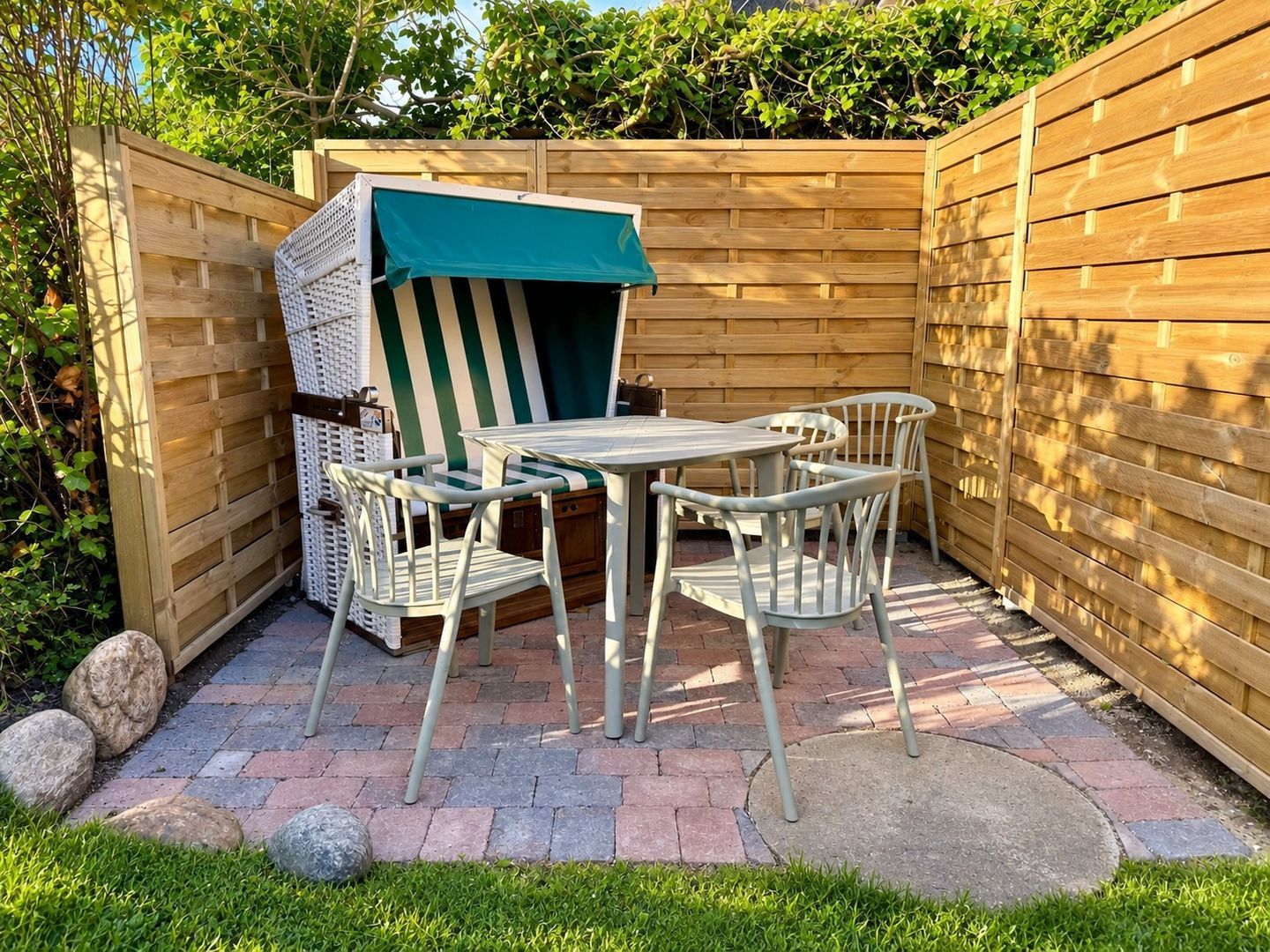 A patio area with a table and chairs, a covered seating area, and a wooden fence.