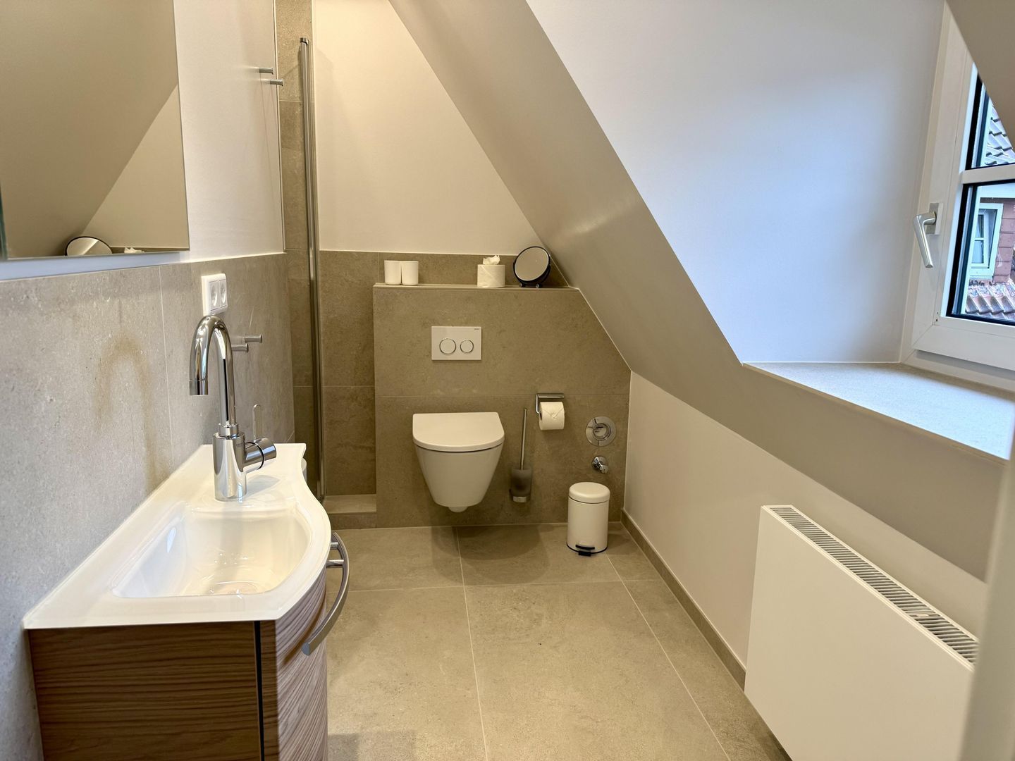 Een moderne badkamer met douche, toilet en wastafel.