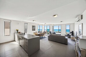 A modern interior with a kitchen, dining area, and living space with large windows overlooking the ocean. - Oceanscapes - U15 Point Grey Lorne (Lorne)