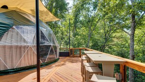A wooden deck with a covered seating area and a transparent dome structure. - Hot Tub & 2 Fire Pits! Secluded Lyles Getaway (Lyles)