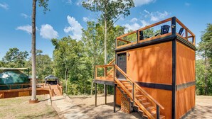 A wooden cabin with a deck, a staircase, and a covered seating area. - Hot Tub & 2 Fire Pits! Secluded Lyles Getaway (Lyles)