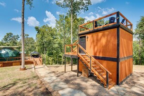 Eine Holzhütte mit einer Veranda, einer Treppe und einem überdachten Sitzbereich.