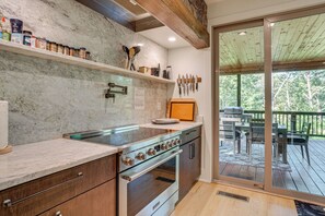 A kitchen with a glass cooktop, wooden cabinets, and a built-in oven. - Sauna, Hot Tub, Mtn View! Stunning Home Near Helen (Sautee Nacoochee)