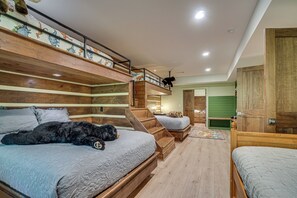 A multi-level bedroom with bunk beds, a staircase, and a small sitting area. - Sauna, Hot Tub, Mtn View! Stunning Home Near Helen (Sautee Nacoochee)