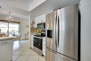 A modern kitchen with stainless steel appliances, including a refrigerator, microwave, and oven. - Families w/ Pets! Home 10 Mi to Busch Gardens (Tampa)