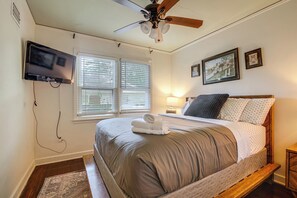 A bedroom with a bed, a ceiling fan, a TV mounted on the wall, and a window with blinds. - Near Midtown Attractions! Memphis Duplex (Memphis)