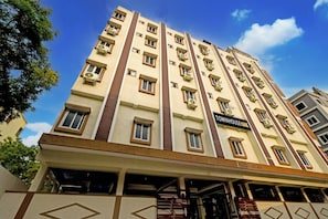 A multi-story hotel with a central entrance, balconies, and a sign indicating 'TOWNHOUSE OAK' on the facade.