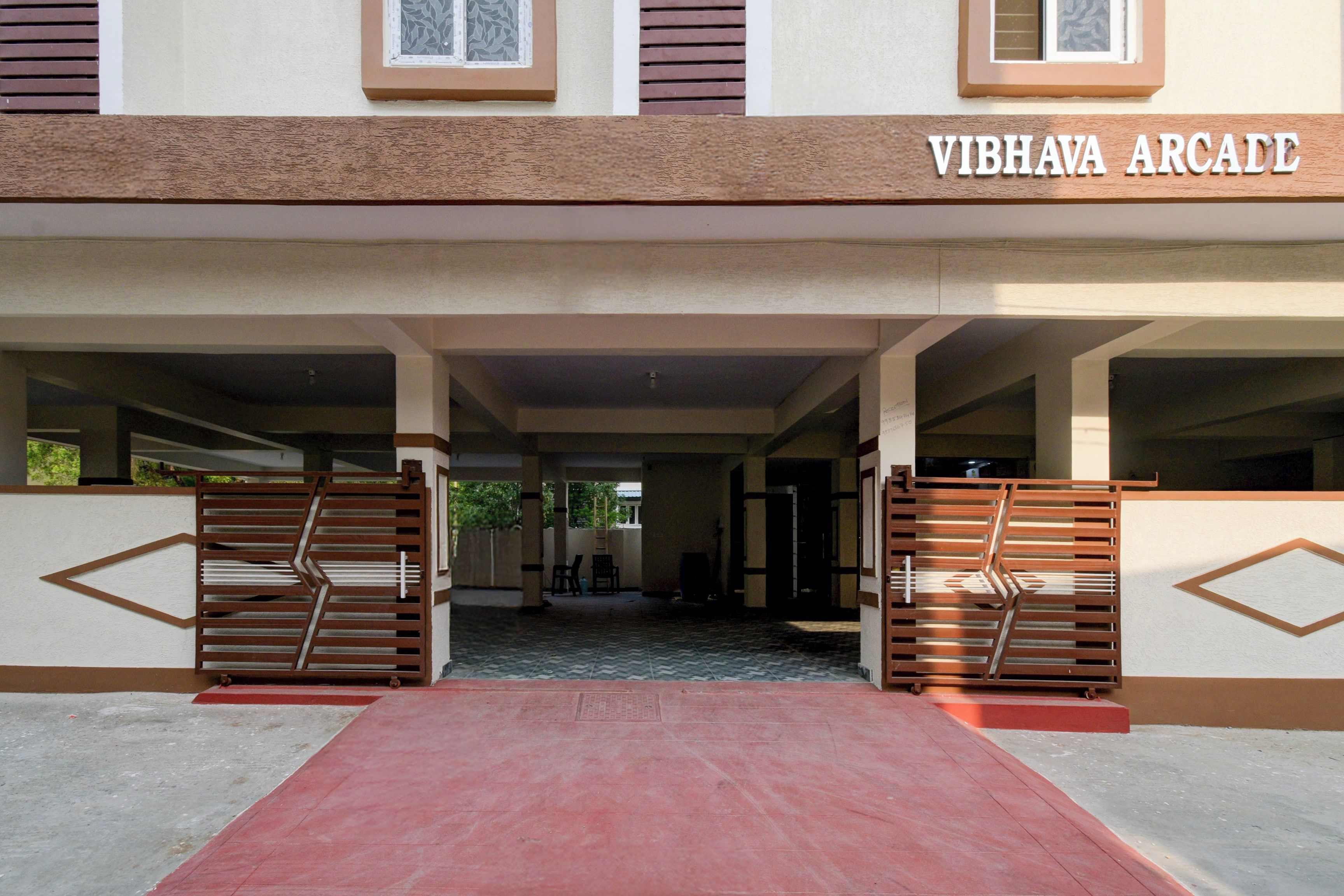 L'ingresso di un edificio con un cartello che riporta 'VIBHAVA ARCADE'.