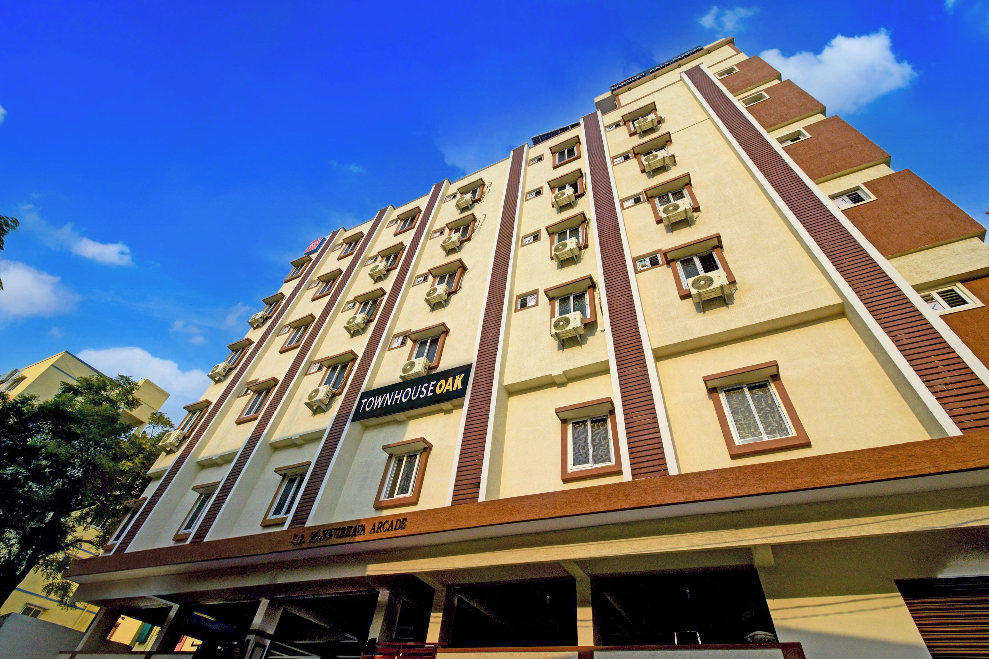 A multi-story building with a sign reading 'TOWNHOUSE OAK' and 'VIBREAVA ARCADE' indicating a commercial space below.