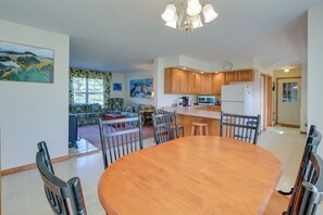A spacious kitchen with wooden cabinets, a dining table, and a built-in microwave.