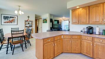 A kitchen with wooden cabinets, a dining table with chairs, and a large island.
