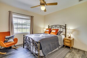 A bedroom with a bed, nightstand, chair, and a ceiling fan. - Families w/ Pets Welcome! Retreat 14 Mi to Tampa (Brandon)