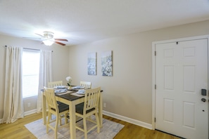 A dining area with a table set for four, a ceiling fan, and a door to the right. - Relax at Oxford Retreat! Experience Ole Miss (Oxford)