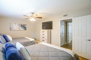 A bedroom with two beds, a ceiling fan, a TV, and a door leading to another room. - Relax at Oxford Retreat! Experience Ole Miss (Oxford)