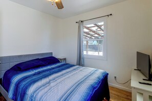 Ein Schlafzimmer mit einem Bett, einem Fernseher und einem Fenster mit Aussicht.