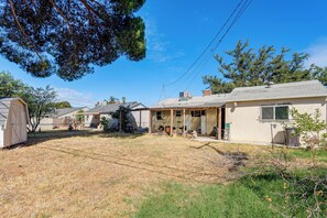 A residential area with houses, a fenced yard, and a clear sky.